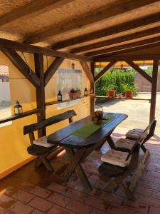 ein Holztisch und Stühle auf einer Terrasse in der Unterkunft Sobe HUBERTUS Lipovac Bajakovo in Lipovac