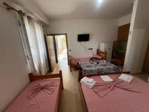 a room with two beds and a kitchen with a tv at Eli Apartments in Tale