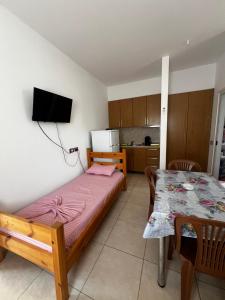 a small bedroom with a bed and a table at Eli Apartments in Tale