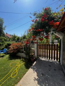 a garden with flowers on a fence with a hose at Eli Apartments in Tale