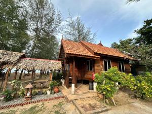 a wooden house with a straw roof at Rumah D'Rhu, Zaki's Residence in Marang