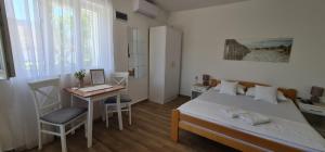 a bedroom with a bed and a desk with a laptop at Apartmani Vidakovic in Igalo