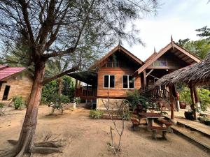 a wooden house with a picnic table in front of it at Rumah D'Rhu, Zaki's Residence in Marang