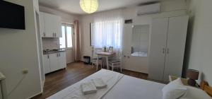 a bedroom with a bed and a kitchen with a table at Apartmani Vidakovic in Igalo