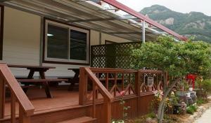 a wooden deck with a picnic table and awning at Buan Mul Love Pension in Buan