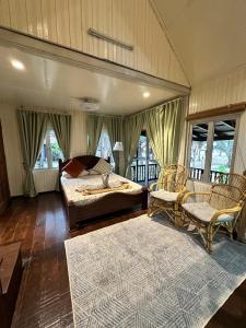 a bedroom with a bed and two chairs and a rug at Rumah D'Rhu, Zaki's Residence in Marang