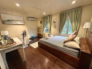 a bedroom with a bed and a desk and a window at Rumah D'Rhu, Zaki's Residence in Marang +3 photos