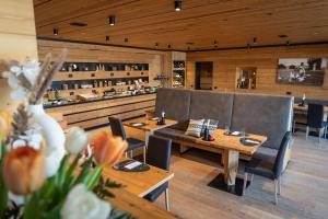 a restaurant with two tables and chairs with flowers at Hotel Li Anta Rossa - Adults Only in Livigno
