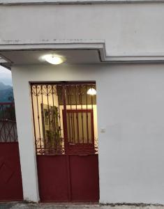 a red door on a white building with a window at Afrodite's Room 1 in Kámbos