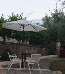 a table and two chairs under an umbrella at Afrodite's Room 1 in Kámbos