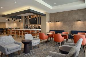 a lobby with tables and chairs and a bar at Holiday Inn Express Houston Downtown by IHG in Houston