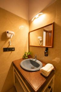 a bathroom with a sink and a mirror at Hotel CozyKey Rajpur Road in Dehradun