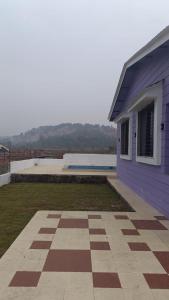 a purple house with a yard next to a building at Vihanka villa in Tāhārpur +2 photos
