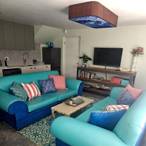 a living room with two blue couches and a tv at Aandster in Paternoster