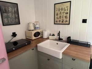 a kitchen counter with a sink and a microwave at Domek Pod Świerkami in Wólka