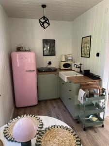 a kitchen with a pink refrigerator and a sink at Domek Pod Świerkami in Wólka +30 photos