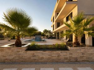two palm trees in front of a building at Villa Illyria in Donji Štoj