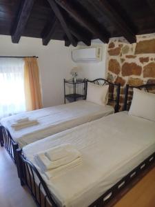 two beds sitting next to each other in a room at Lithos Villas Komitsa in Metókhion Koumítsas