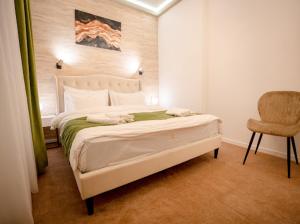 a bedroom with a white bed and a chair at Luna Boutique in Bucharest