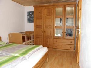 a bedroom with a wooden cabinet and a bed at Ferienwohnung-Rurseeidyll in Simmerath