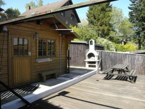 a small wooden cabin with a bench and a grill at Ferienwohnung-Rurseeidyll in Simmerath