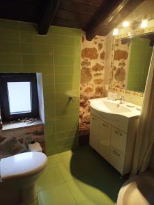 a bathroom with a sink and a toilet and a window at Lithos Villas Komitsa in Metókhion Koumítsas +11 photos