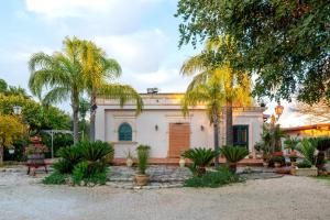 a house with palm trees in front of it at B&B Le Carrube in Sava