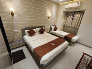 a hotel room with two beds in a room at Hotel Le Glance Rooms & Dormitory in Mumbai