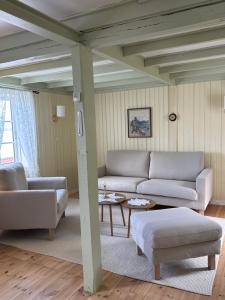 a living room with two couches and a table at Heritage House in Lofoten with Modern Comfort & Scenic Views in Jerstad +24 photos