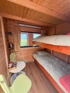 a cabin with two bunk beds and a table and chairs at Dekema Equestrian Trekkershutjes in Gorredijk