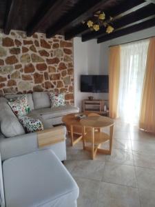 a living room with a couch and a table at Lithos Villas Komitsa in Metókhion Koumítsas