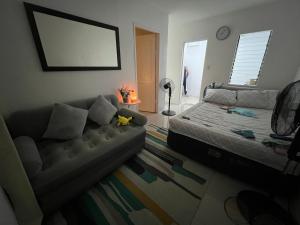 a living room with a bed and a couch at Alexeis Place in Manolo Fortich