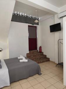a room with a bed and a staircase with a red door at Afrodite's Room 1 in Kámbos