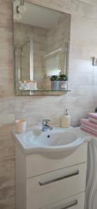 a bathroom with a sink and a mirror and towels at Apartment Jovana in Igalo +6 photos