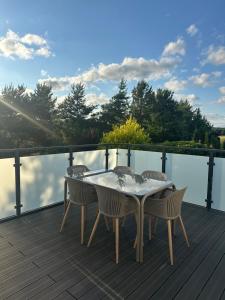a table and chairs on a deck with a view of the water at Ciche Tarasy in Stężyca