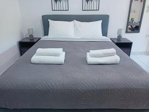 ein großes Bett mit zwei weißen Handtüchern darauf in der Unterkunft Lemon Suites in Mytilini