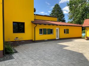 a yellow house with a driveway in front of it at Harztor in Nordhausen +15 photos