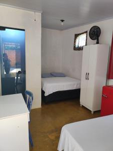a small room with two beds and a cabinet at Cantinho da Lobeira in Alto Paraíso de Goiás
