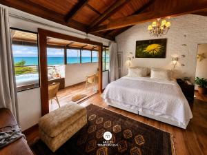 a bedroom with a bed and a view of the ocean at Pousada Ondas da Grande - Penha/SC in Penha