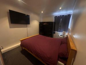 a bedroom with a bed and a flat screen tv at Home from Home 1 in Castleford
