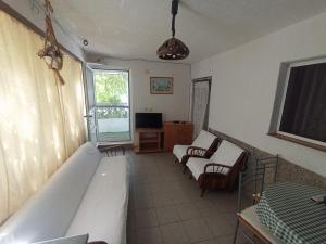 a living room with two beds and a television at Holidays Svetin Apartments in Grebaštica