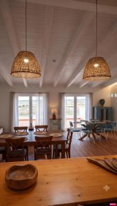 a dining room with tables and chairs and windows at Herdade do Cascalhar in Vila do Bispo