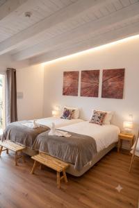 a bedroom with a large bed and two tables at Herdade do Cascalhar in Vila do Bispo