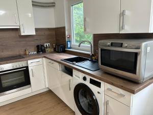 a kitchen with a microwave and a dishwasher at Premium Apart Villa Hamburg in Hamburg