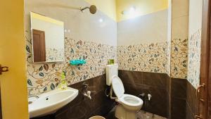 a bathroom with a sink and a toilet and a mirror at New royal dormitory in Raipur