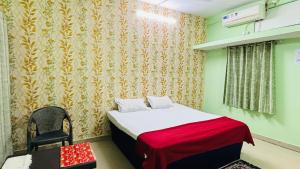 a bedroom with a bed and a chair in it at New royal dormitory in Raipur