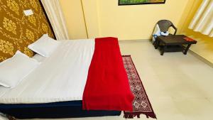 a bedroom with a bed with a red blanket on it at New royal dormitory in Raipur +2 photos