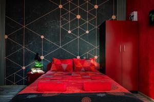 a red bedroom with a large red bed with red pillows at Къща за гости Мурите in Sapareva Banya +67 photos