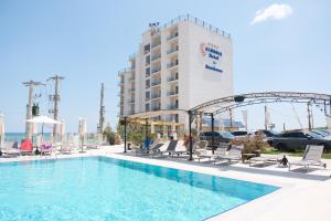 a large swimming pool with chairs and a hotel at Alessio Hotel Residence in Costinesti
