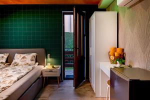 a room with a bed and a green wall at Къща за гости Мурите in Sapareva Banya